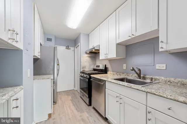 a kitchen with stainless steel appliances granite countertop a refrigerator sink and stove