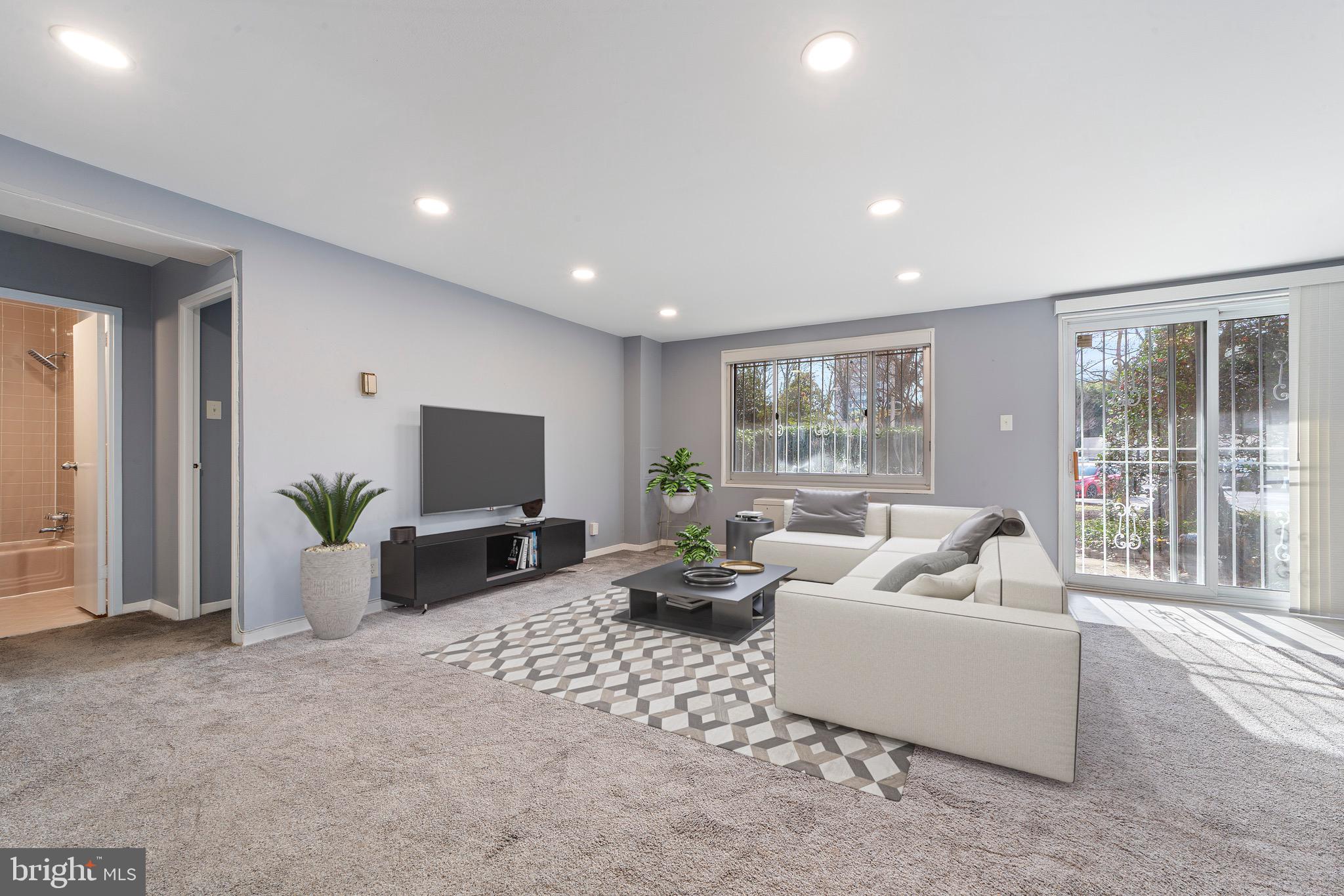 1900 Lyttonsville Road, Unit 111 Silver Spring, MD 20910 - Photo 5 of 21 a living room with furniture and large windows