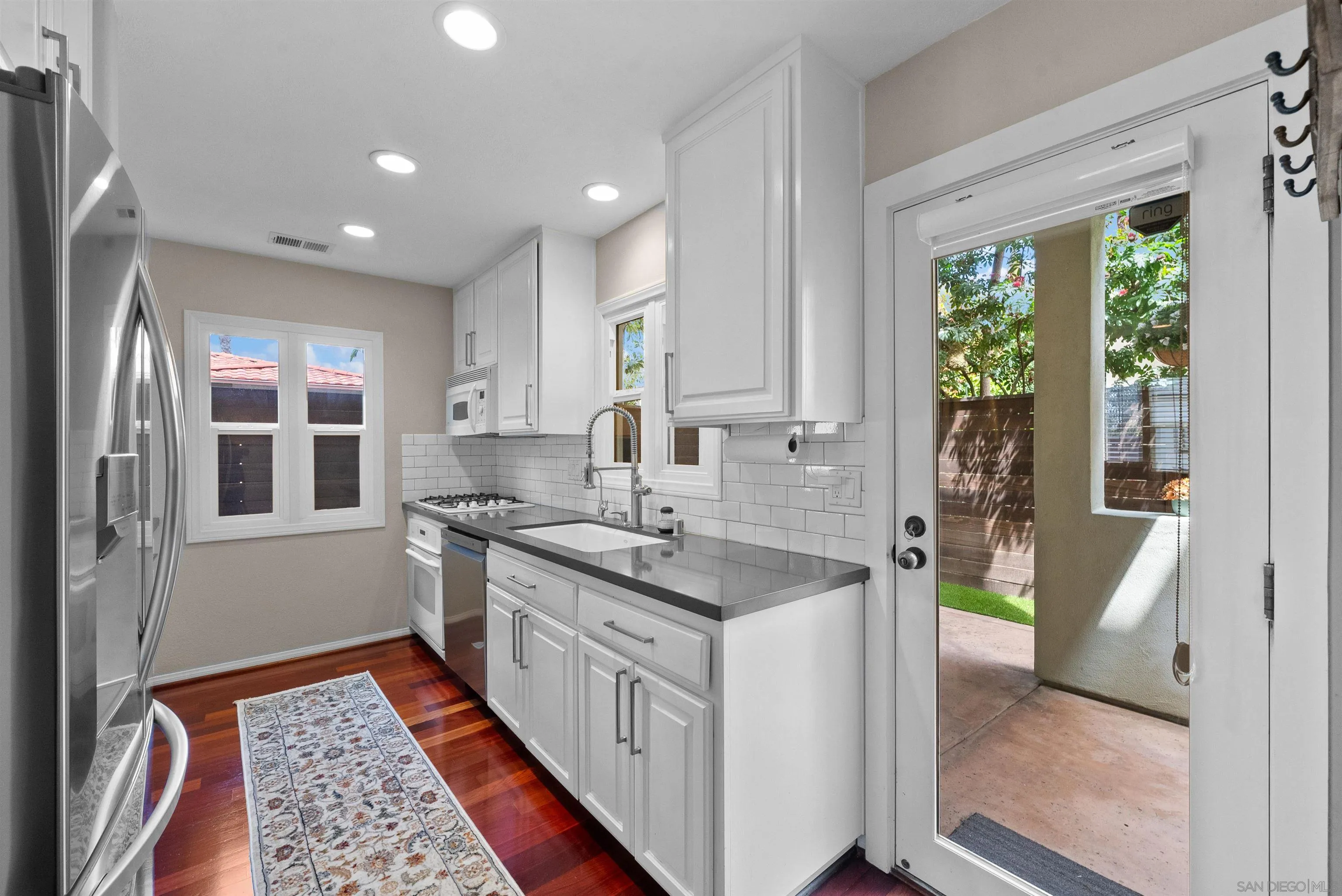 6755 Tyrian Street La Jolla, CA 92037 - Photo 14 of 60 a kitchen with a sink stove and cabinets
