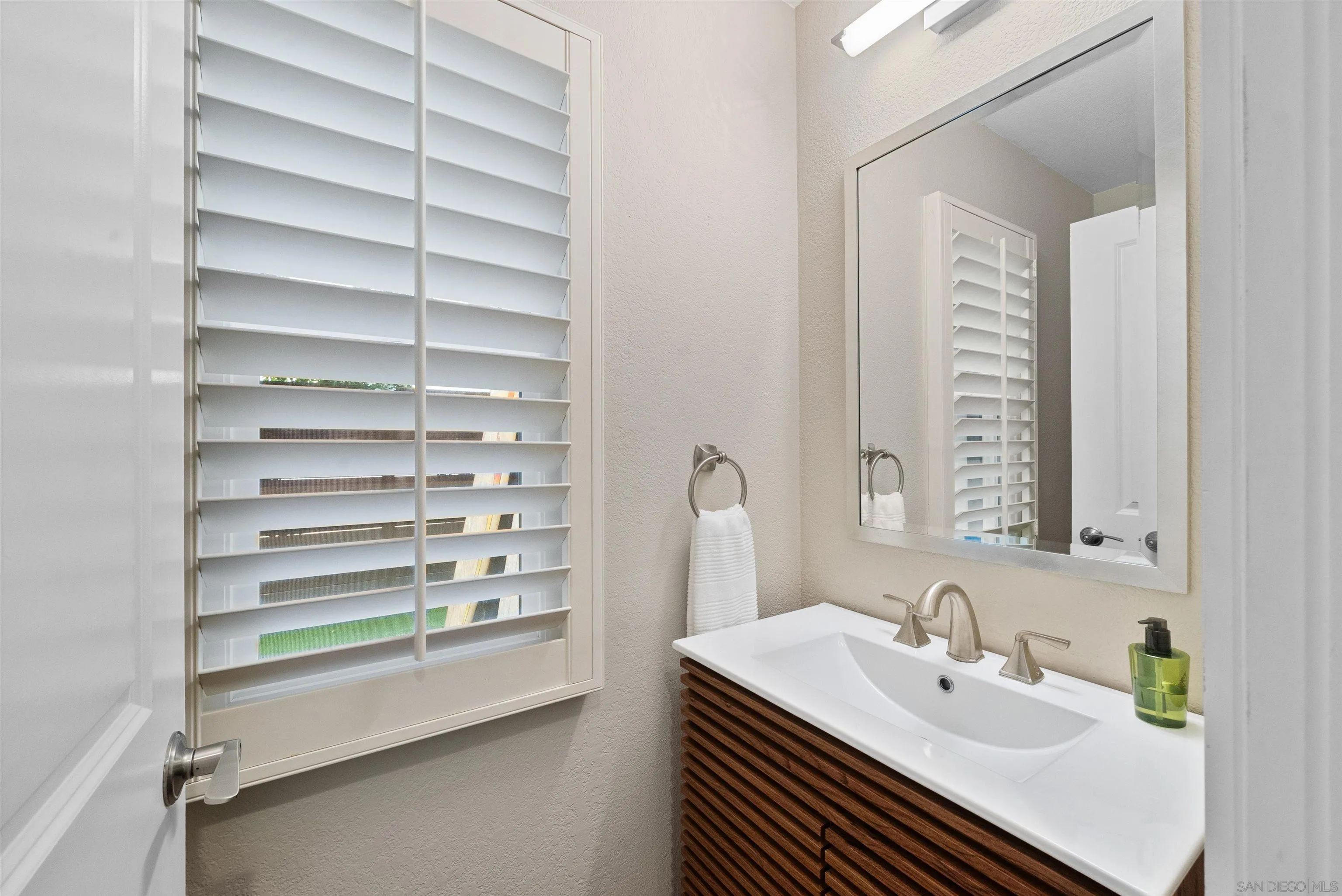 6755 Tyrian Street La Jolla, CA 92037 - Photo 18 of 60 a bathroom with a sink a vanity and a mirror