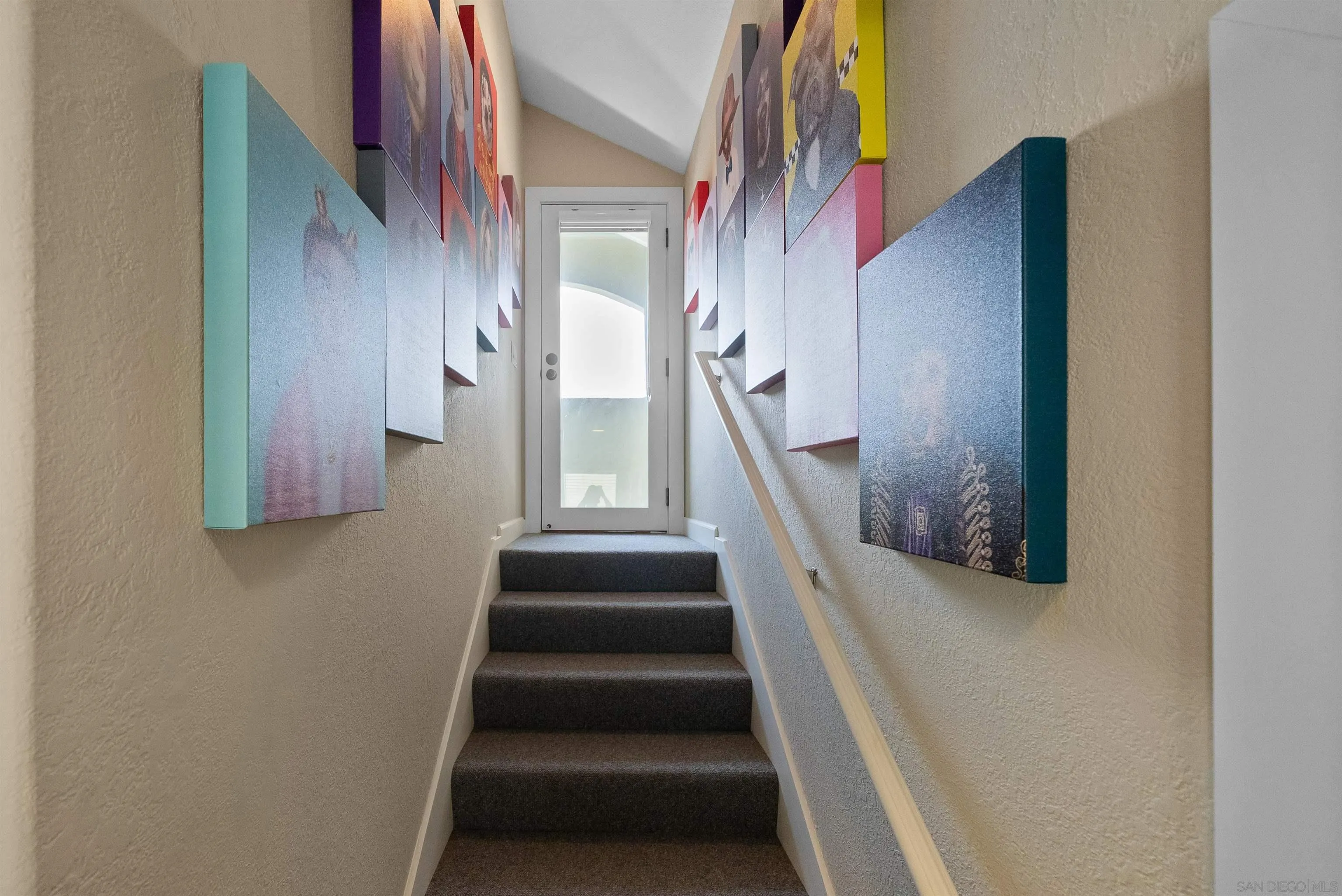 6755 Tyrian Street La Jolla, CA 92037 - Photo 31 of 60 a view of staircase with lots of frames on wall and a window