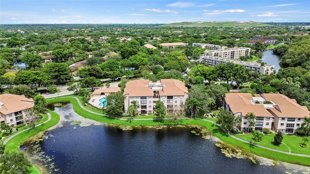 an aerial view of a house with a garden and lake view