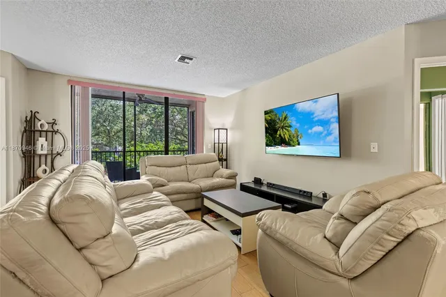 a living room with furniture large windows and a flat screen tv
