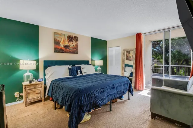 a spacious bedroom with a bed a couch and large window