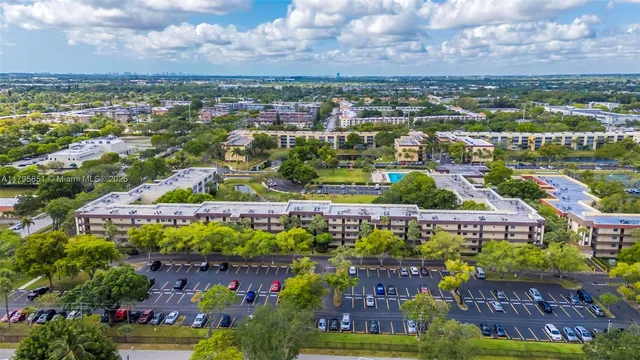 an aerial view of residential houses with outdoor space and trees