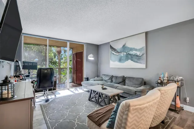 a living room with furniture large window and flat screen tv