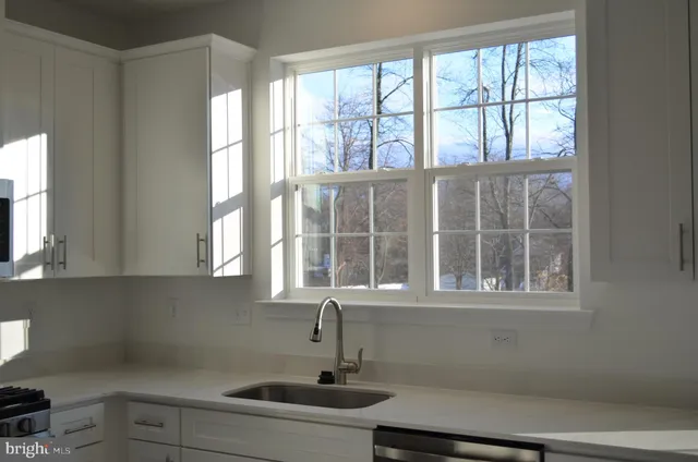 a bathroom with a sink window and mirror