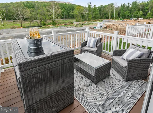 a view of a roof deck with couches and wooden floor