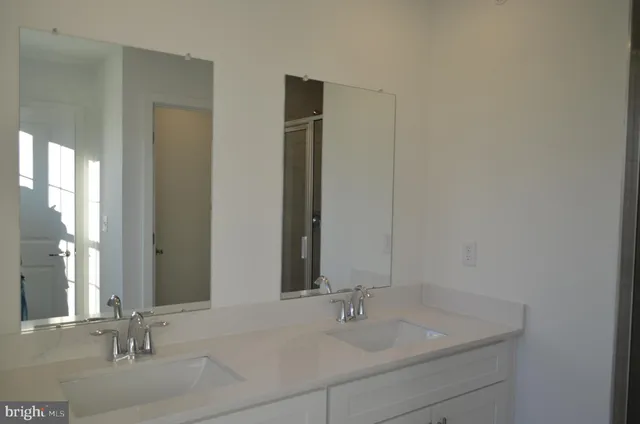 a bathroom with double vanity sinks and a mirror