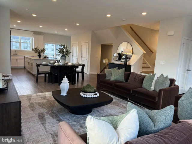 a living room with furniture and a dining table with kitchen view