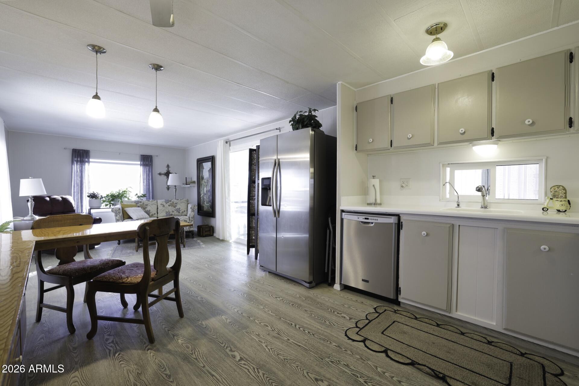 8600 East Broadway Road, Unit 13 Mesa, AZ 85208 - Photo 3 of 16 a kitchen with stainless steel appliances granite countertop a refrigerator a sink dishwasher a stove and white cabinets with wooden floor