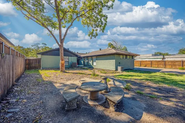 a view of a house with backyard and sitting area