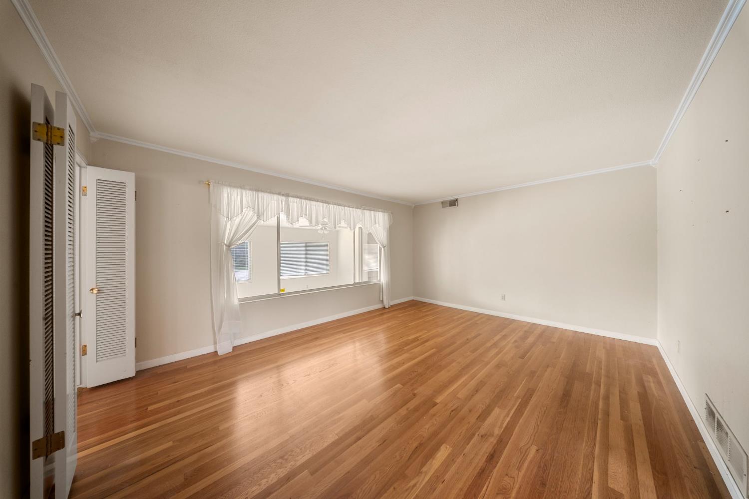 1500 Crestview Drive Modesto, CA 95355 - Photo 5 of 32 a view of an empty room with wooden floor and a window
