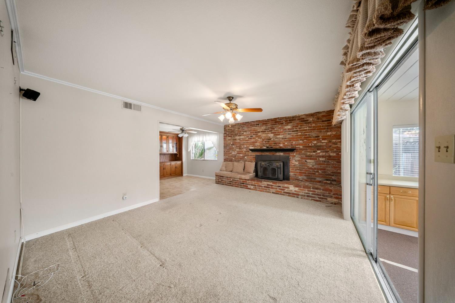 1500 Crestview Drive Modesto, CA 95355 - Photo 8 of 32 an empty room with a fireplace and chandelier