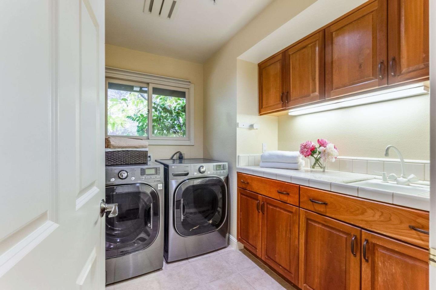 22340 Regnart Road Cupertino, CA 95014 - Photo 20 of 74 a bathroom with a sink a washer and dryer next to a window