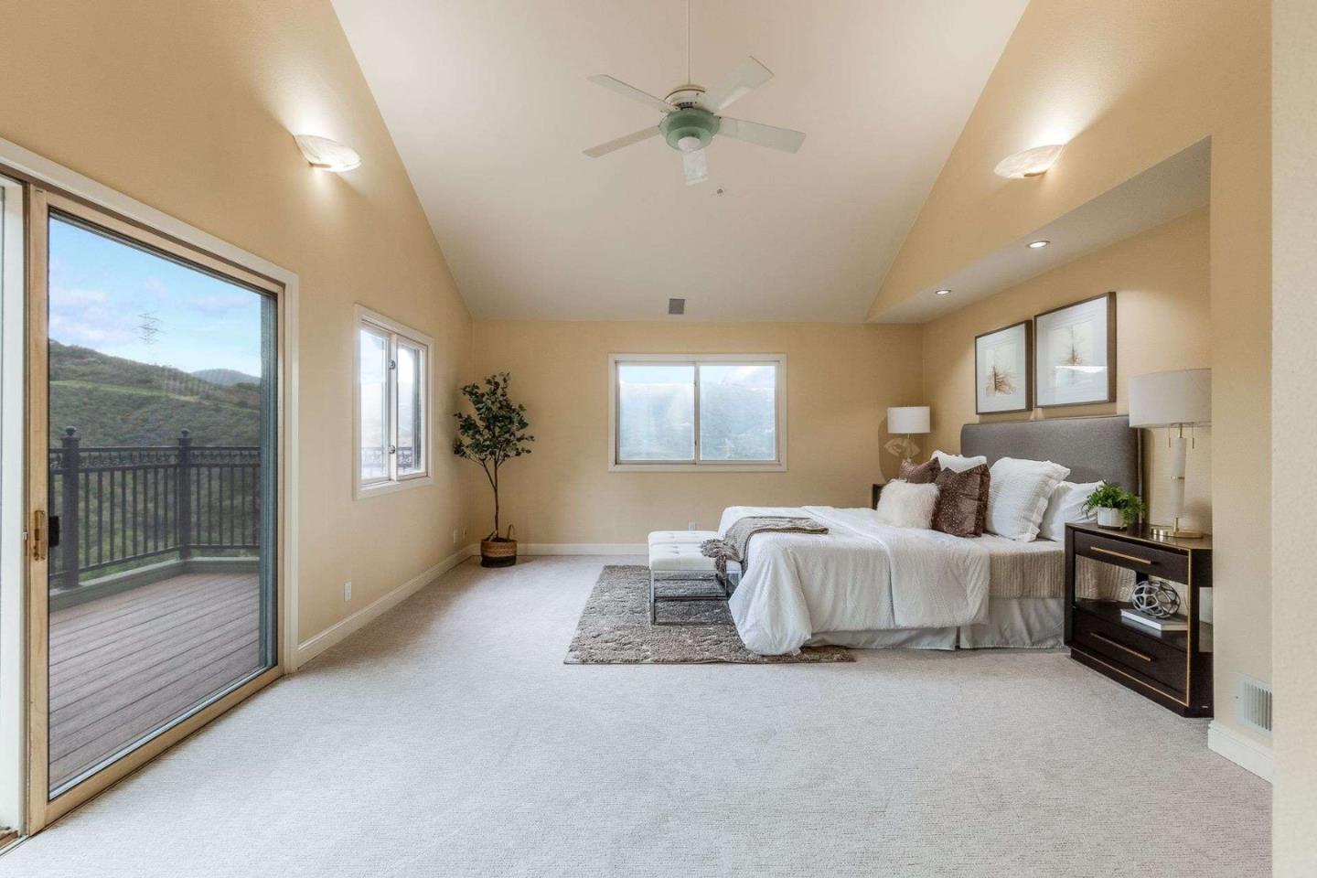 22340 Regnart Road Cupertino, CA 95014 - Photo 22 of 74 a spacious bedroom with a bed and a chandelier