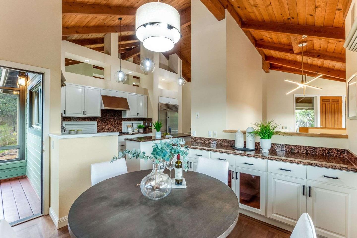22340 Regnart Road Cupertino, CA 95014 - Photo 7 of 74 a kitchen with stainless steel appliances kitchen island granite countertop a stove a sink and a dining table with wooden floor