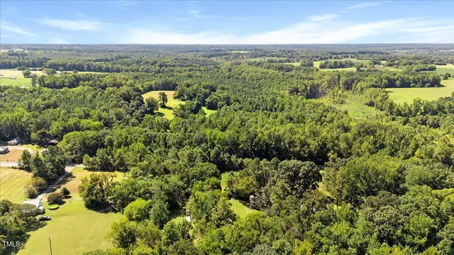 an aerial view of a house with a mountain