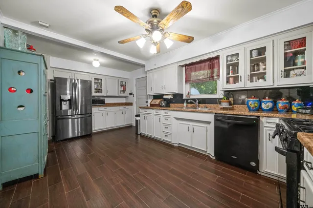 a kitchen with stainless steel appliances granite countertop a sink a stove and a wooden cabinets