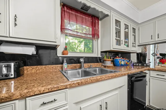 a bedroom with a bed a couch and a flat tv screen on the dresser