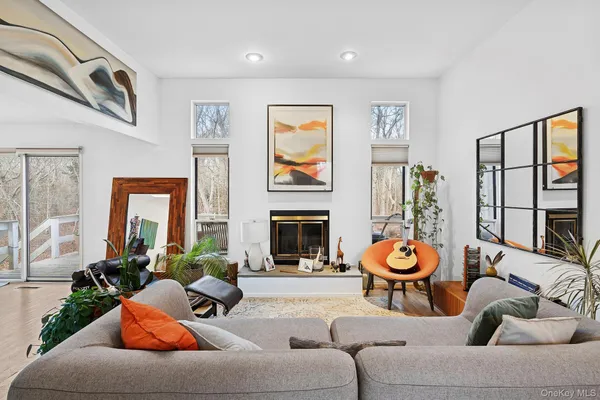 a living room with furniture a fireplace and a large window