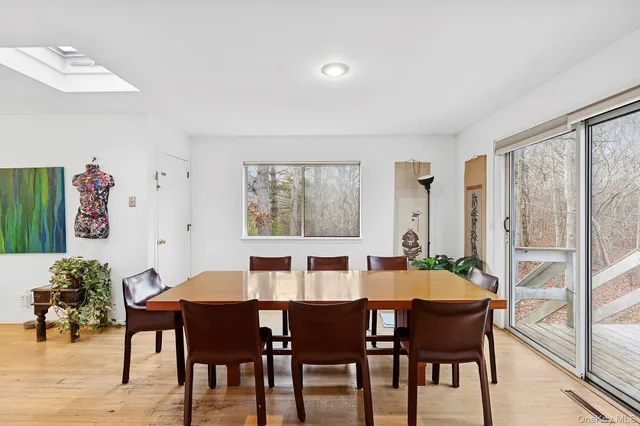 a dining room with furniture a rug and a potted plant