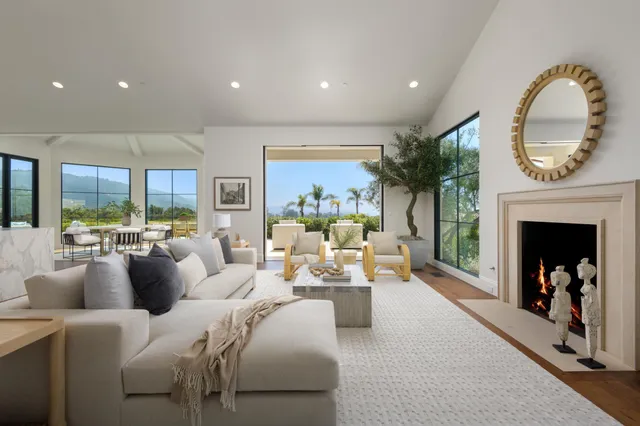 a living room with furniture fireplace and a large window