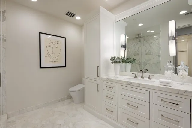 a bathroom with a granite countertop sink mirror and toilet