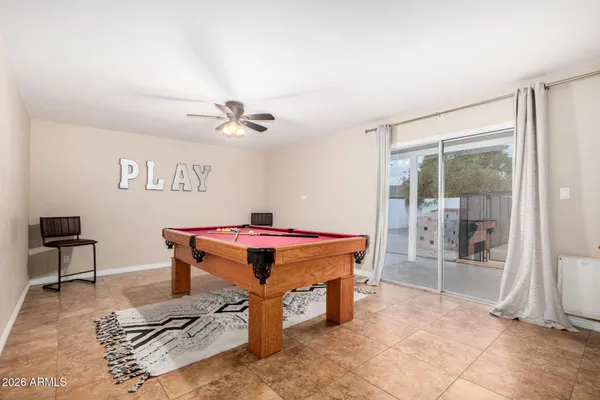 a room with pool table and ceiling fan