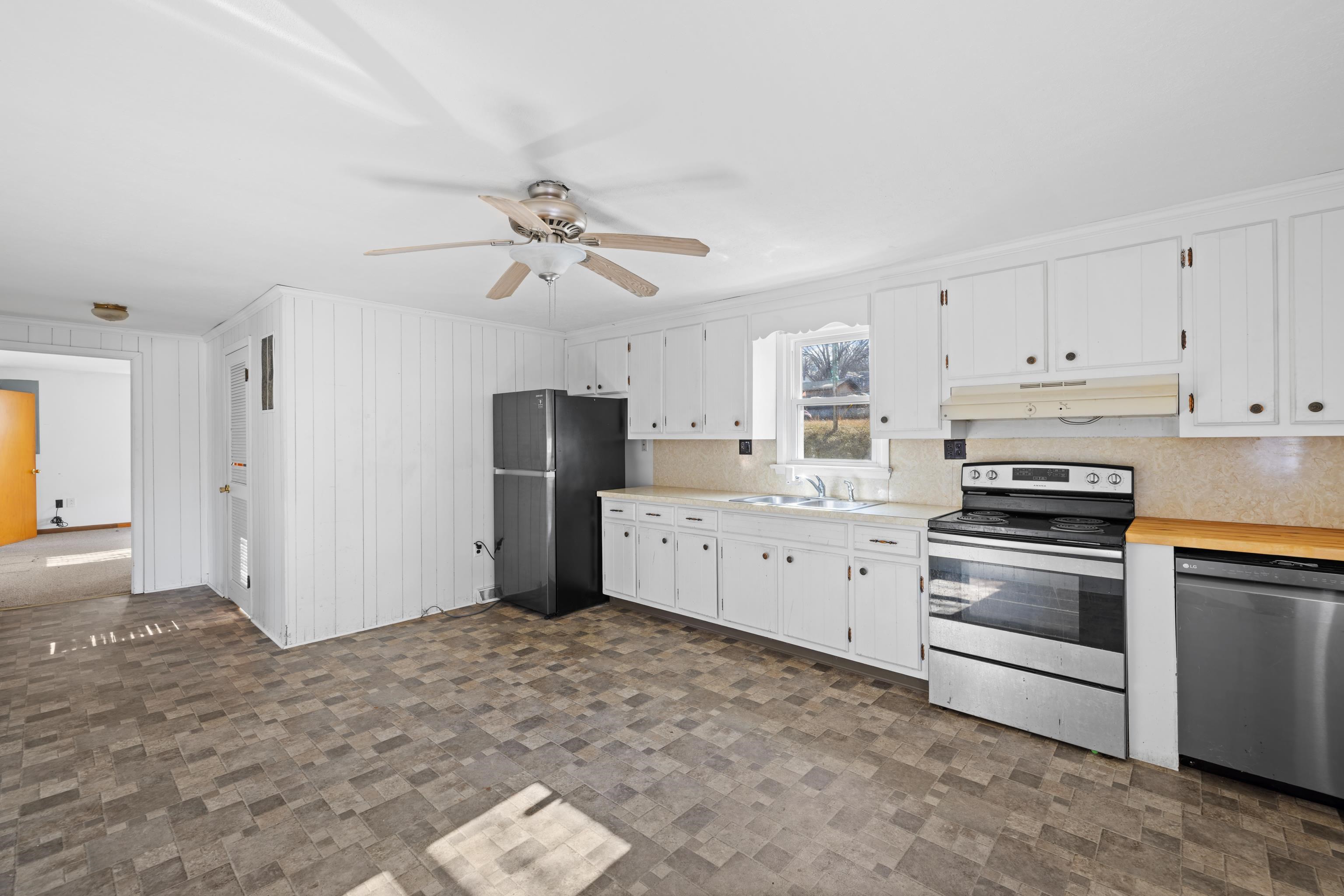 1340 B Street Waynesboro, VA 22980 - Photo 15 of 52 a kitchen with granite countertop a refrigerator oven a sink dishwasher and white cabinets