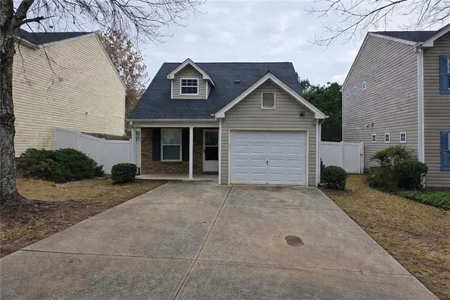 a view of a house with a yard and garage