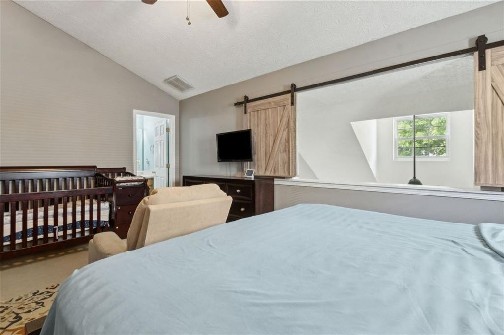163 Silver Fox Trail Dallas, GA 30157 - Photo 14 of 35 a bedroom with bed and a flat tv screen on dresser