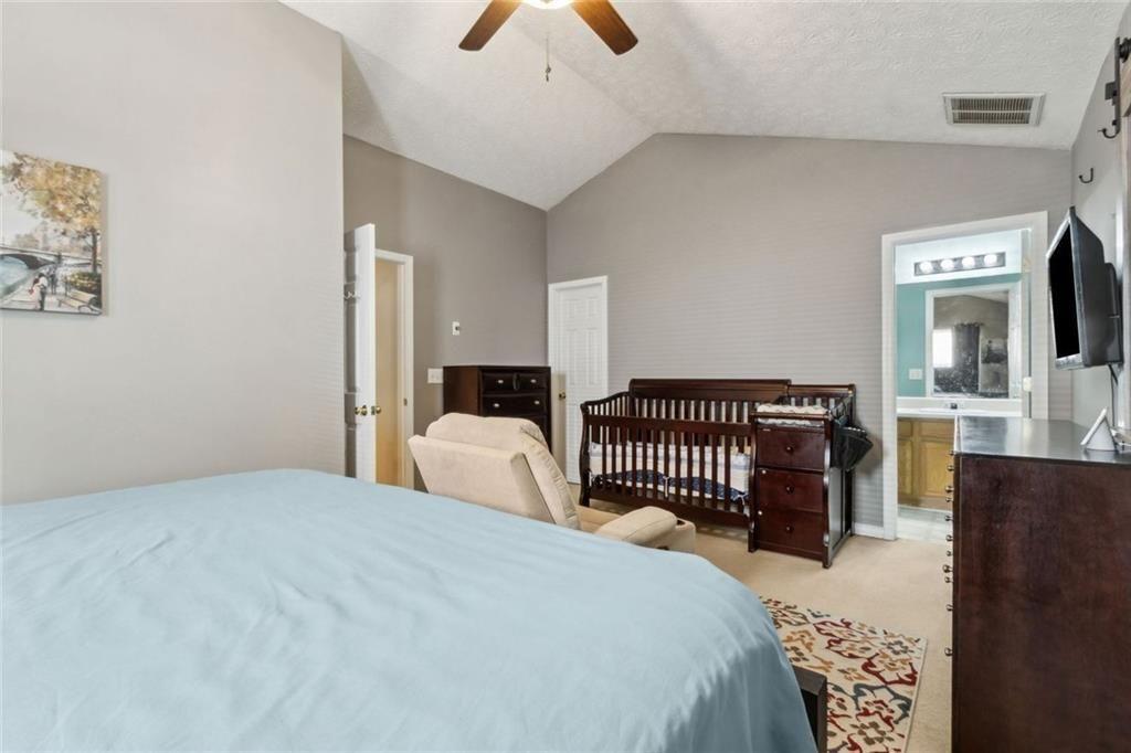 163 Silver Fox Trail Dallas, GA 30157 - Photo 15 of 35 a bedroom with a bed and a chandelier