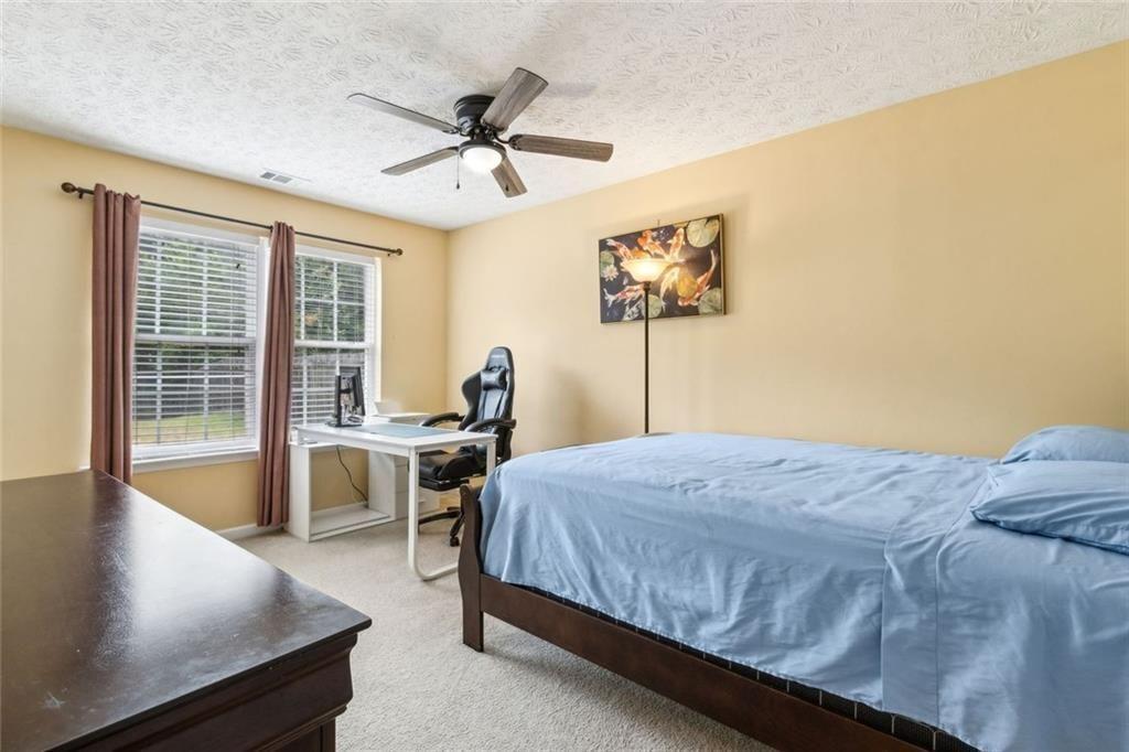163 Silver Fox Trail Dallas, GA 30157 - Photo 21 of 35 a bedroom with a bed and a chandelier