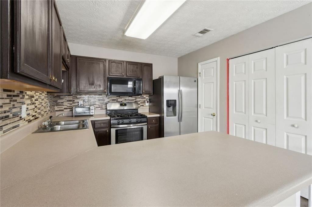 163 Silver Fox Trail Dallas, GA 30157 - Photo 3 of 35 a kitchen with stainless steel appliances granite countertop a refrigerator stove and sink