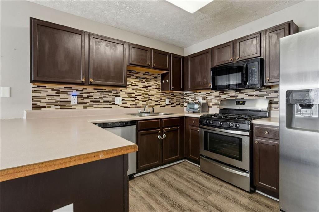 163 Silver Fox Trail Dallas, GA 30157 - Photo 7 of 35 a kitchen with stainless steel appliances granite countertop a stove microwave and sink