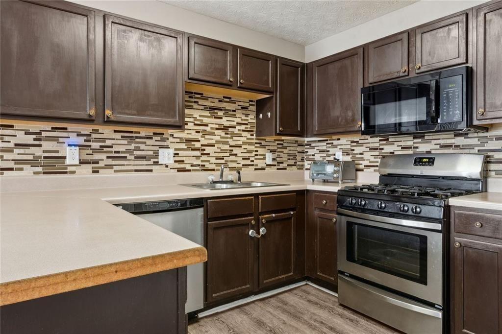 163 Silver Fox Trail Dallas, GA 30157 - Photo 8 of 35 a kitchen with stainless steel appliances wooden cabinets and a stove top oven