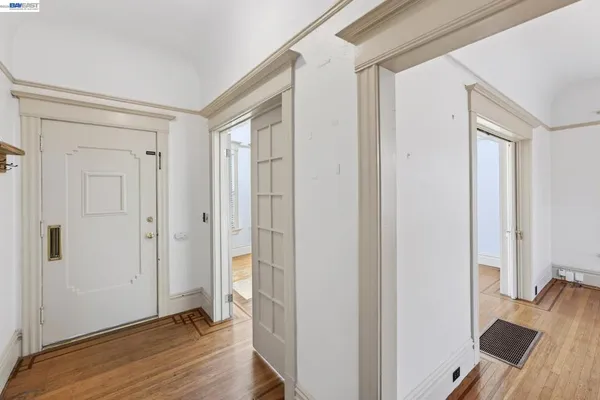 a view of a hallway with wooden floor and closet area