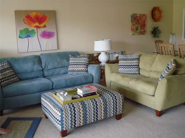 a living room with furniture a couch and painting on the wall