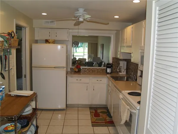 a kitchen with a refrigerator a sink and cabinets