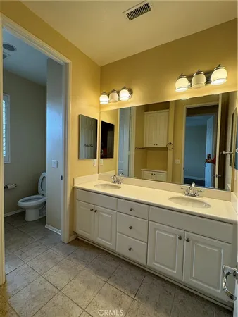 a spacious bathroom with a double vanity sink and a mirror