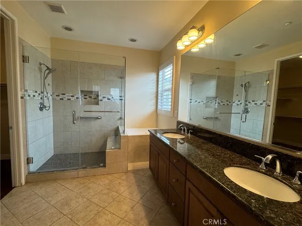 a bathroom with a granite countertop sink tub shower and a mirror
