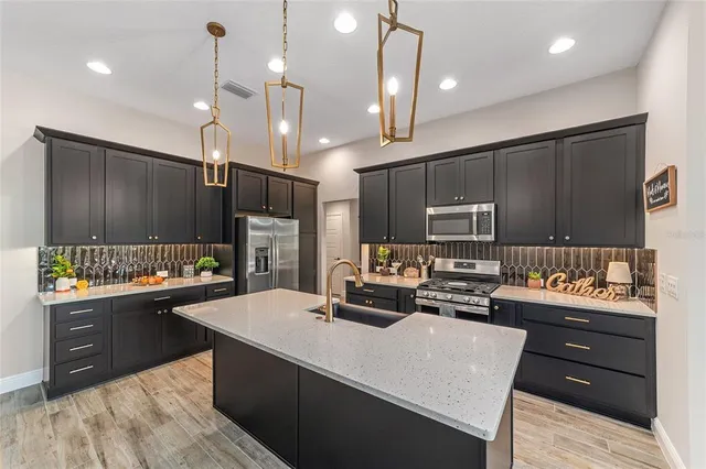 a kitchen with kitchen island a sink stove and refrigerator