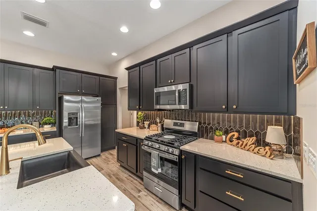 a kitchen that has a sink cabinets counter space and stainless steel appliances