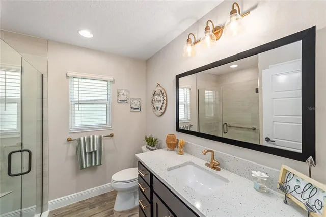 a bathroom with a granite countertop sink a toilet and a mirror