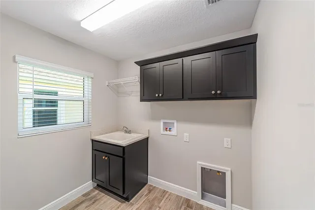a room with a window and wooden cabinets