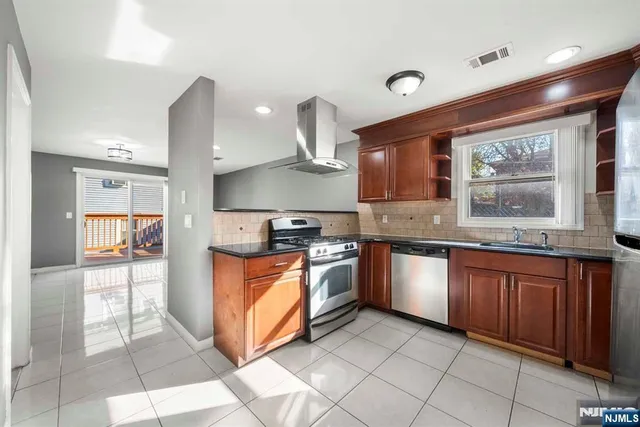 a kitchen with stainless steel appliances granite countertop a stove sink and cabinets