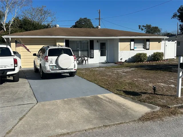 a front view of a house with cars parked