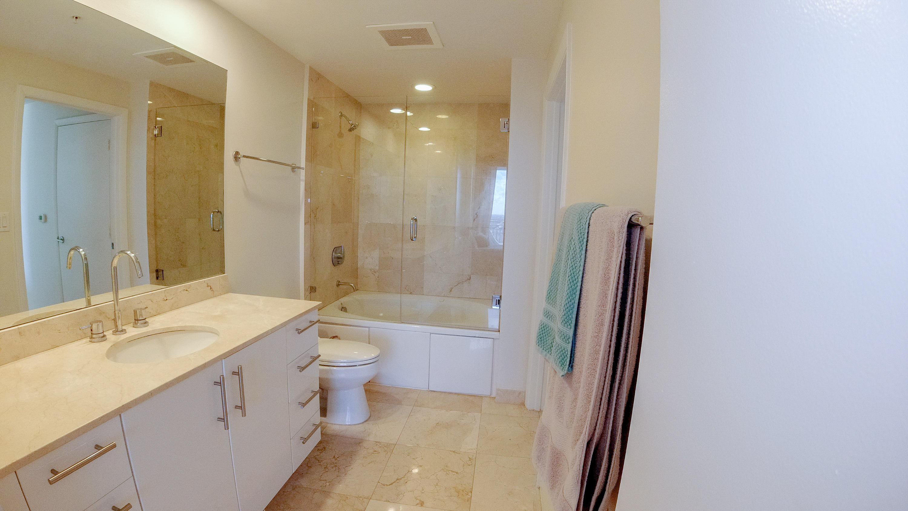 550 Okeechobee Boulevard, Unit 1721 West Palm Beach, FL 33401 - Photo 4 of 12 a bathroom with a granite countertop sink toilet a large mirror a shower and a bathtub