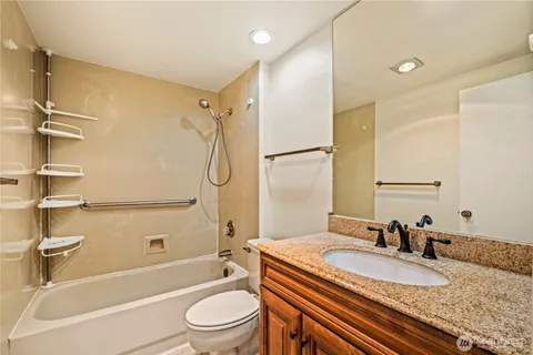 a bathroom with a granite countertop sink toilet and shower